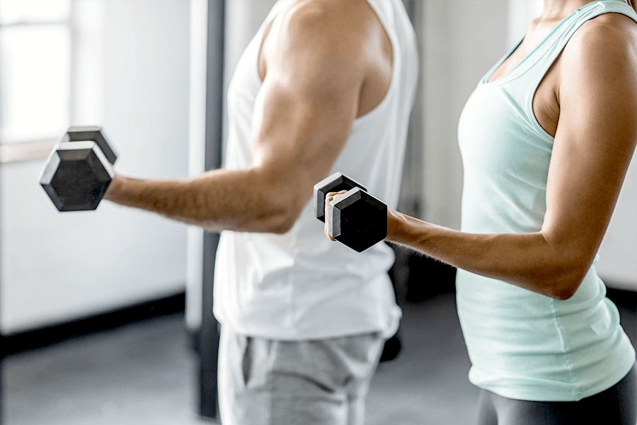 Man and woman lifting weights at the gym