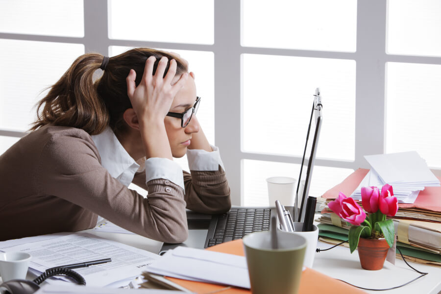 Female office worker slouched at her desk, wondering "What is posture?"