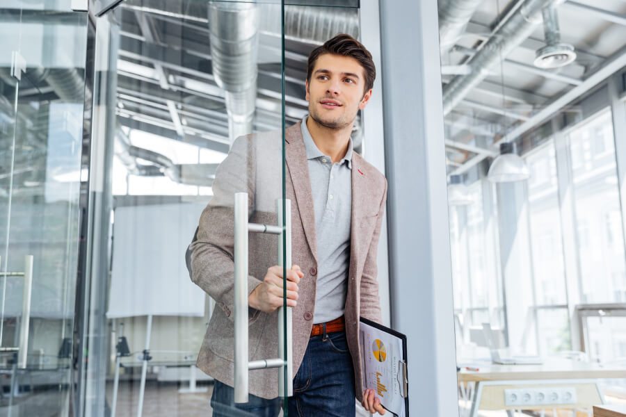 Man entering office through glass door