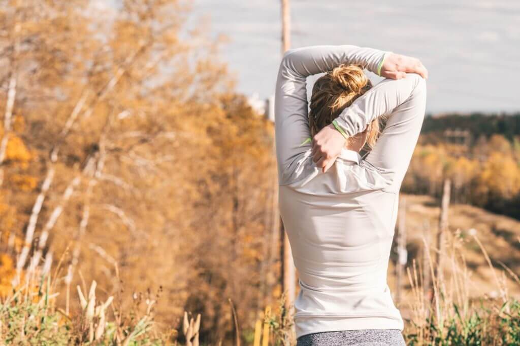 Woman exercising outside stretching her arms