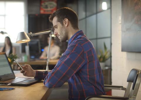 Man taking a break at work looking at his smartphone