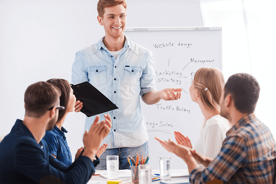 Man with good posture giving a presentation to four colleagues