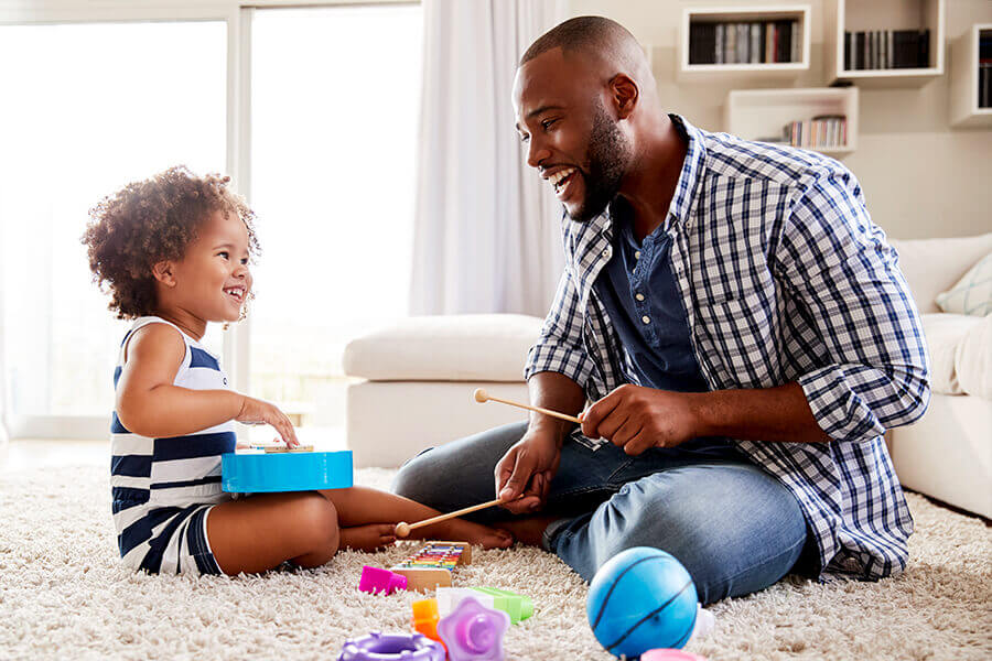 Father and daughter playing with toys on the floor