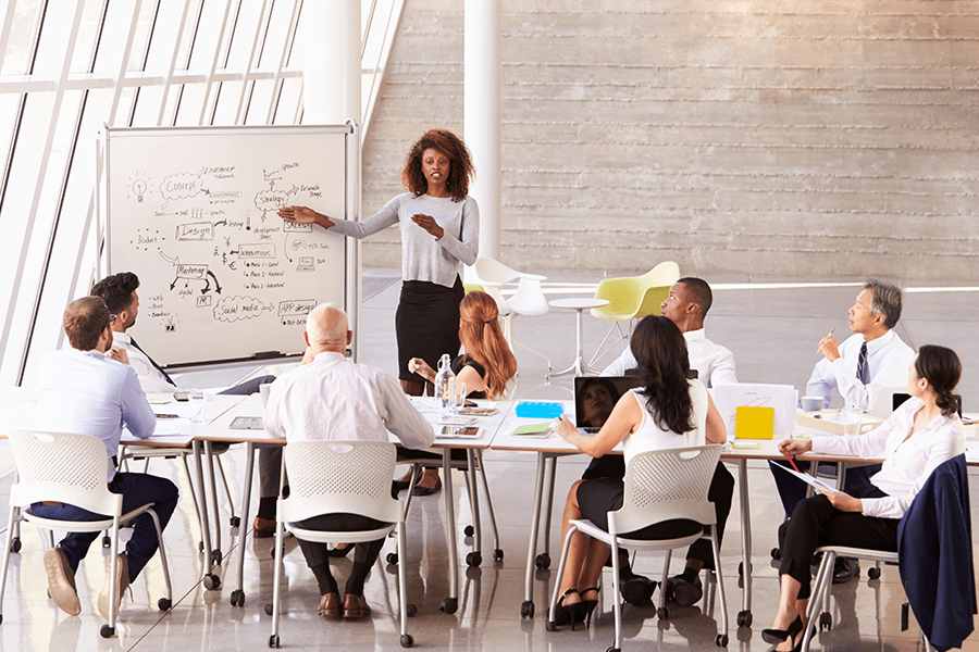 Woman with good posture confidently giving a presentation to her colleagues