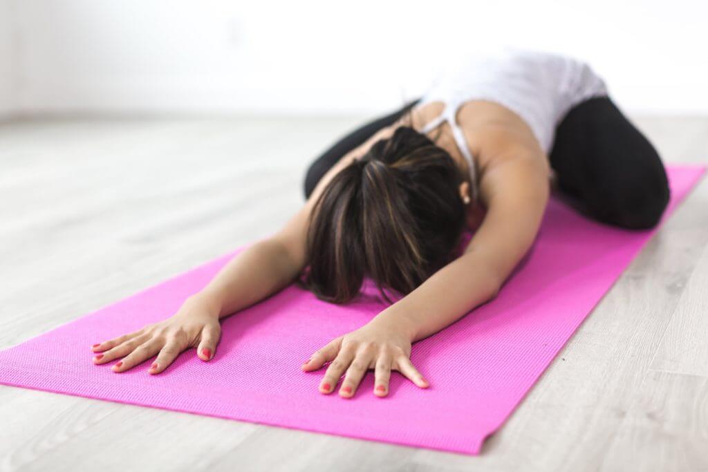 Woman doing yoga on a yoga mat to improve her posture
