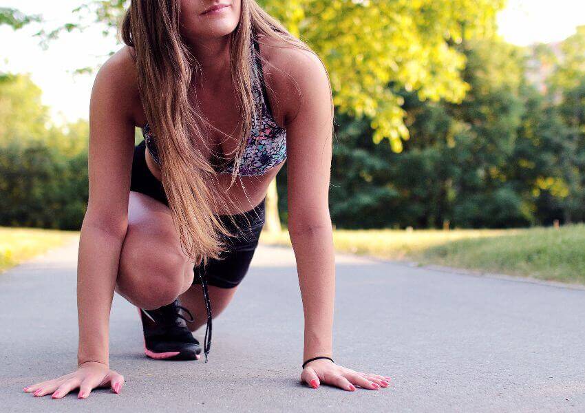 Woman stretching outside before exercising to improve her posture