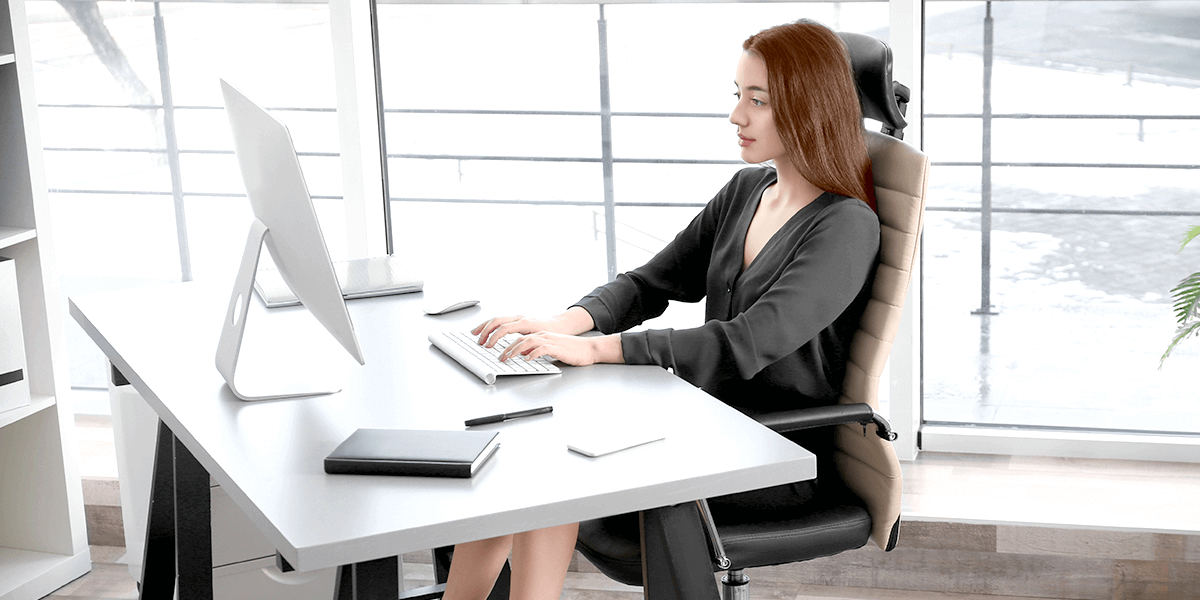 Woman with good posture avoiding pain while typing on her computer