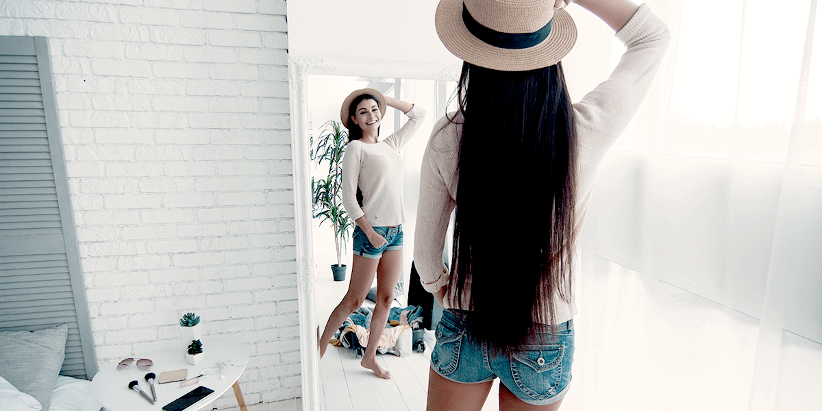 Woman posing and smiling to herself in a mirror